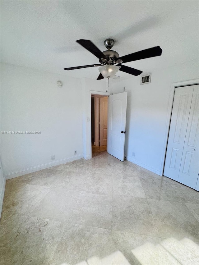 unfurnished bedroom featuring a textured ceiling, ceiling fan, and a closet