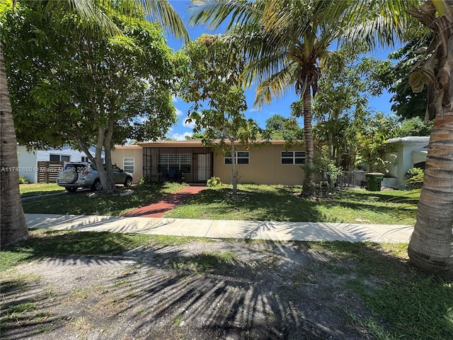 1445 NE 136th St, North Miami, FL 33161 - view of front of property featuring stucco siding and a front lawn