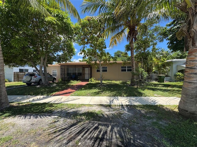 1445 NE 136th St, North Miami, FL 33161 - view of front facade with a front lawn and stucco siding