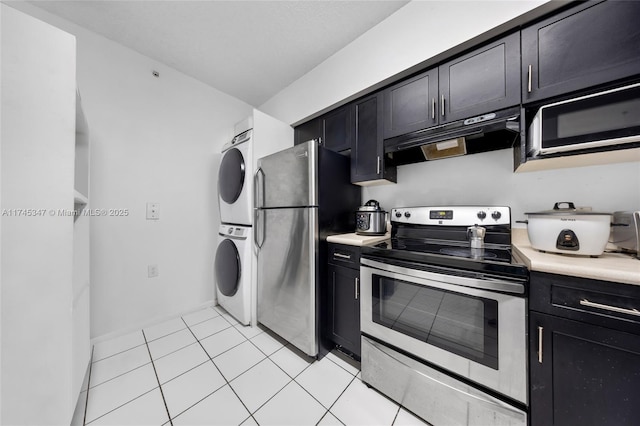 kitchen with stainless steel appliances, stacked washer and dryer, and light tile patterned floors