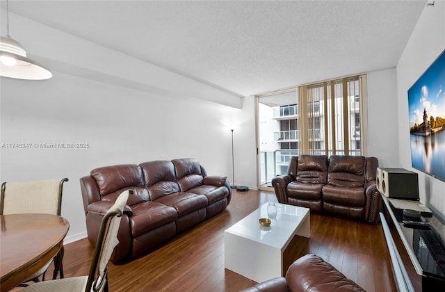 living room featuring a wall of windows, dark hardwood / wood-style floors, and a textured ceiling