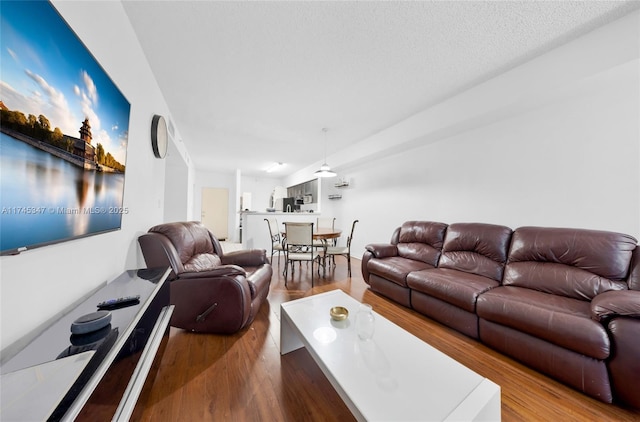 living room with wood-type flooring and a textured ceiling