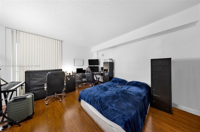 bedroom with dark hardwood / wood-style floors and a textured ceiling