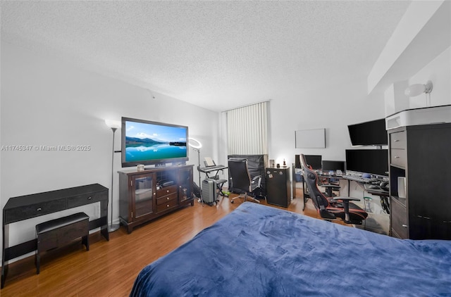 bedroom with wood-type flooring and a textured ceiling