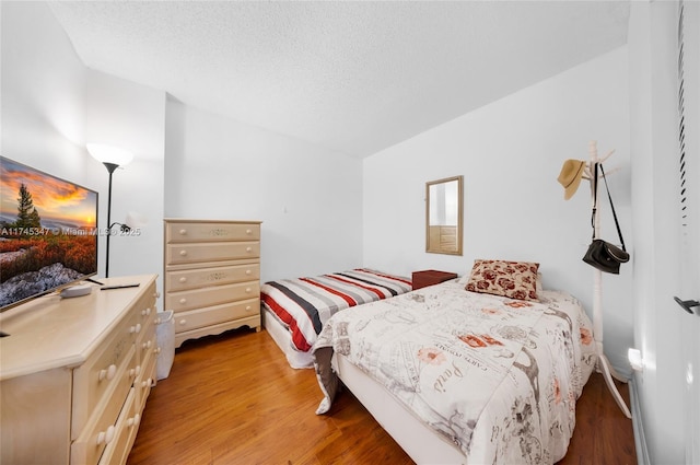 bedroom featuring hardwood / wood-style flooring and a textured ceiling