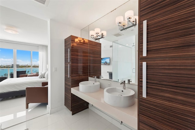 bathroom featuring vanity, a notable chandelier, tile patterned flooring, and a shower with shower door