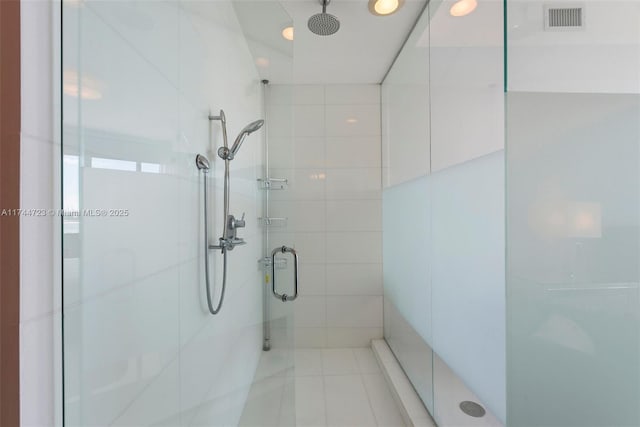 bathroom with a shower with shower door and tile walls