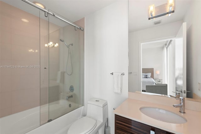 full bathroom featuring enclosed tub / shower combo, vanity, and toilet