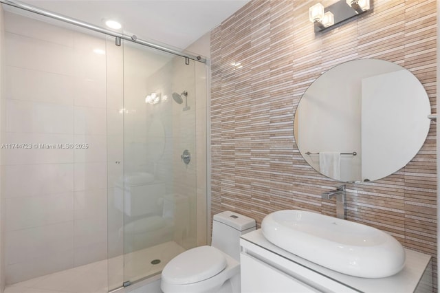 bathroom featuring walk in shower, toilet, tile walls, vanity, and backsplash