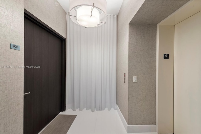 corridor with tile patterned flooring and elevator