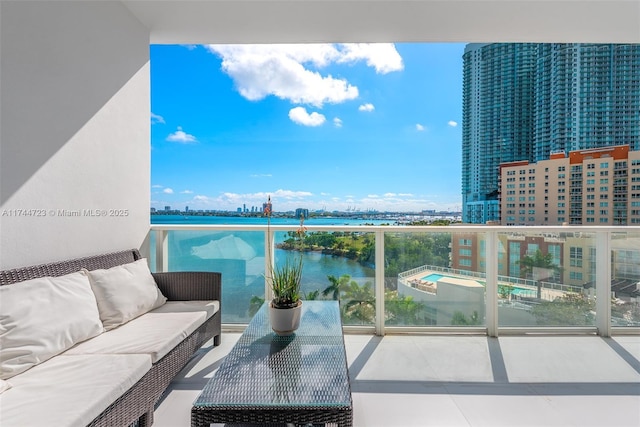 balcony with a water view and an outdoor living space