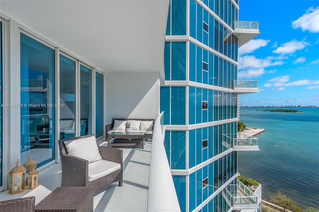 balcony featuring a water view and an outdoor hangout area