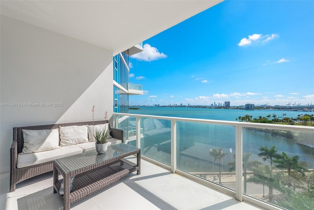 balcony featuring an outdoor living space and a water view