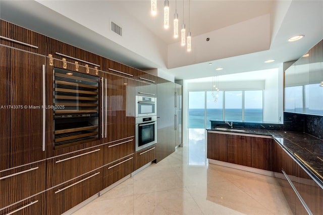 2711 S Ocean Dr Unit 3302, Hollywood, FL 33019 - kitchen featuring pendant lighting, a water view, tasteful backsplash, beverage cooler, and stainless steel double oven