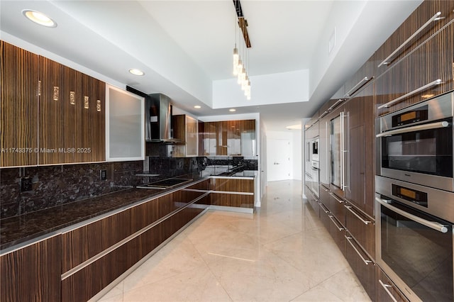 2711 S Ocean Dr Unit 3302, Hollywood, FL 33019 - kitchen featuring pendant lighting, dark stone countertops, double oven, tasteful backsplash, and wall chimney exhaust hood