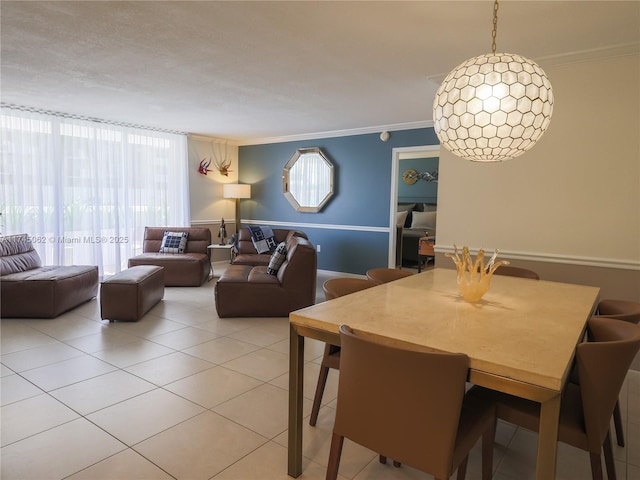 dining room with light tile patterned floors and crown molding