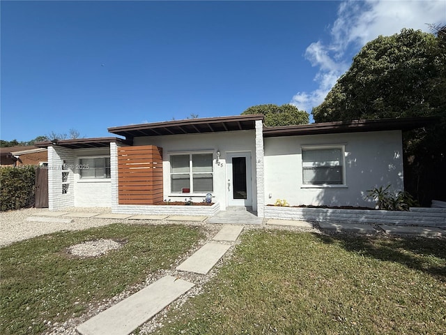 view of front of property with stucco siding and a front lawn