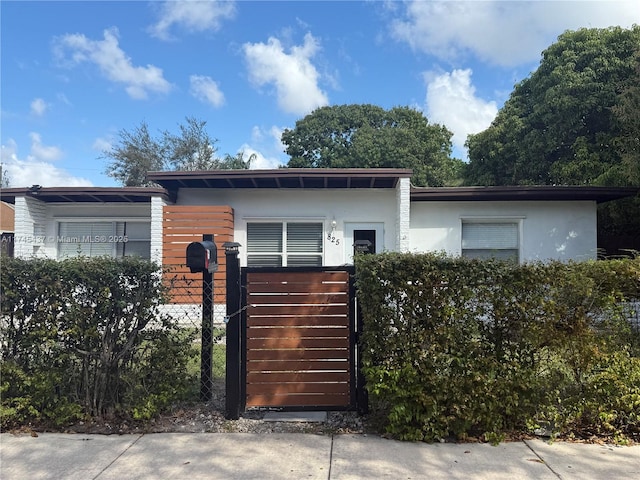 view of front of home featuring a fenced front yard, a gate, and stucco siding