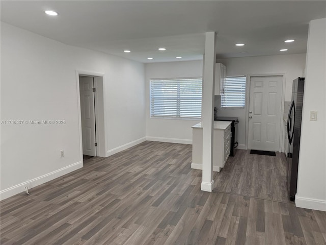 interior space featuring recessed lighting, baseboards, black appliances, and dark wood finished floors