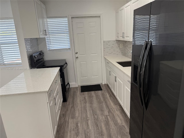 kitchen with white cabinetry, dark wood-type flooring, decorative backsplash, light stone countertops, and black appliances