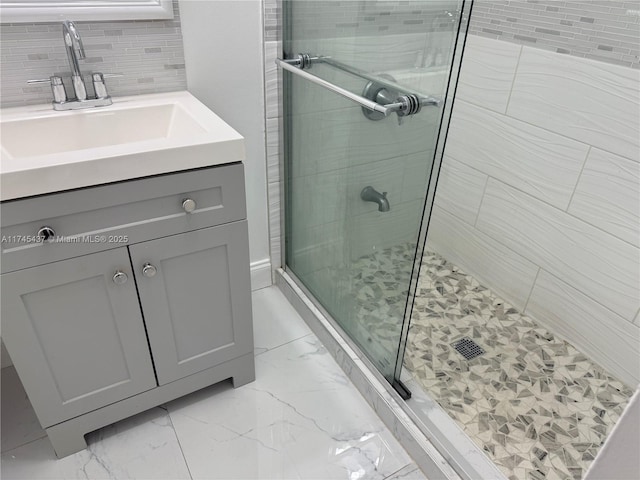 bathroom featuring marble finish floor, a stall shower, and vanity