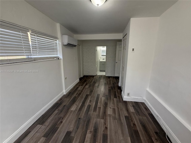 hallway featuring baseboards, a wall mounted AC, dark wood-style floors, and a healthy amount of sunlight