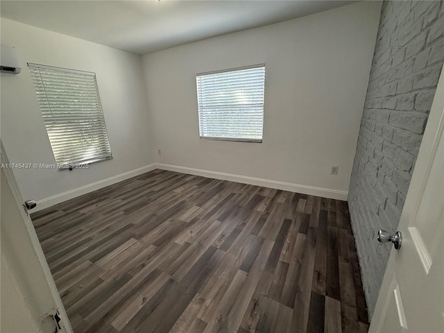 empty room with dark wood finished floors and baseboards