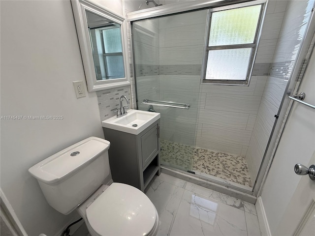 bathroom with a shower stall, marble finish floor, toilet, vanity, and backsplash