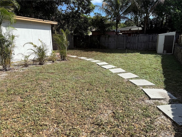 view of yard with a fenced backyard, a shed, and an outdoor structure