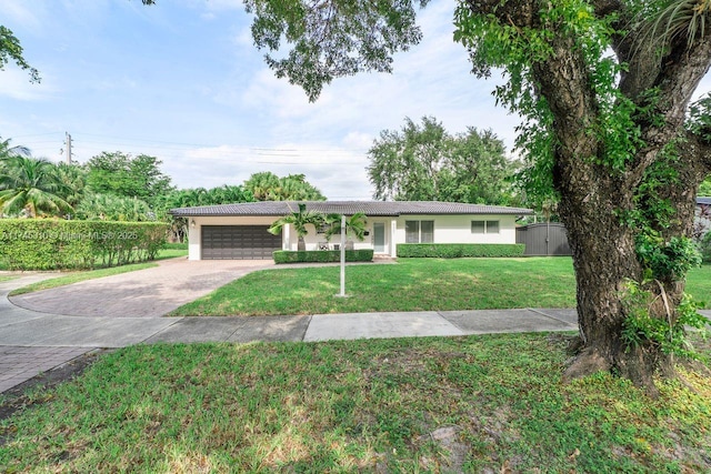 ranch-style house featuring a garage and a front yard