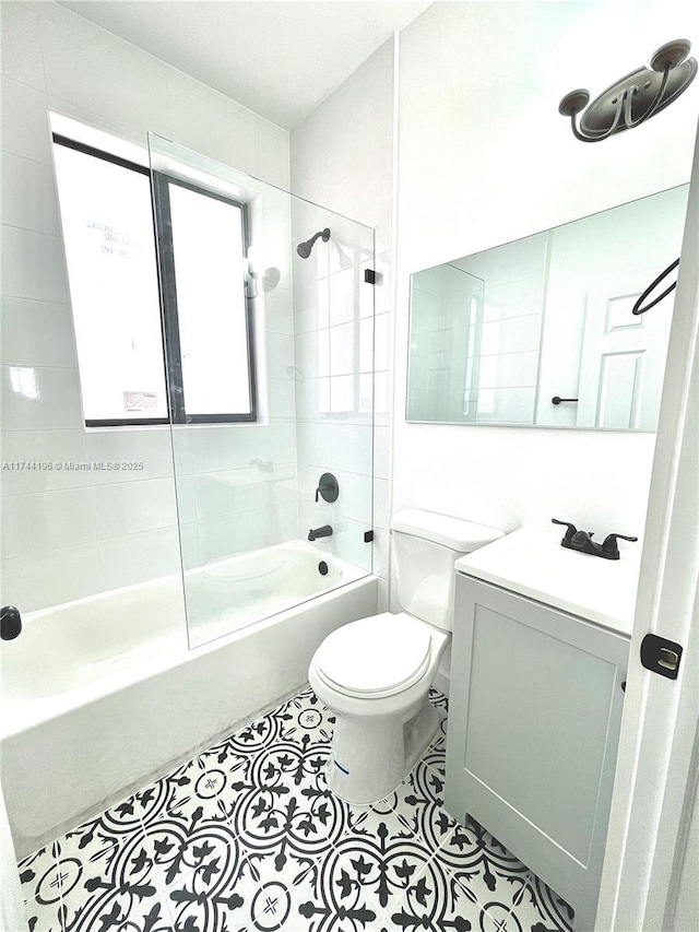 full bathroom featuring vanity, tile patterned floors, toilet, and tiled shower / bath