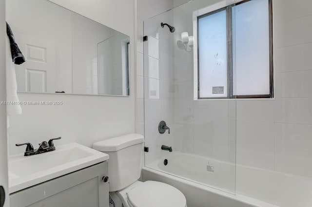 full bathroom with tiled shower / bath combo, vanity, and toilet