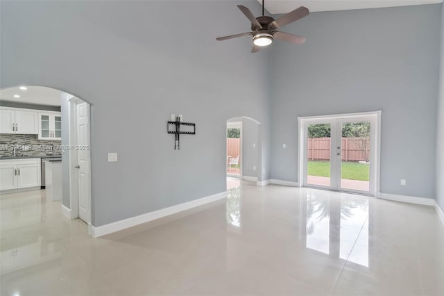 interior space featuring ceiling fan, sink, and a high ceiling