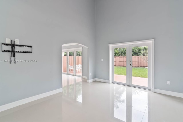 empty room featuring french doors and a high ceiling