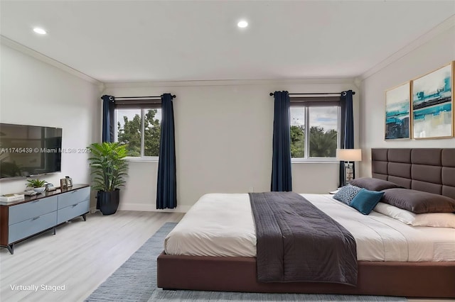 bedroom featuring multiple windows, crown molding, and light hardwood / wood-style floors