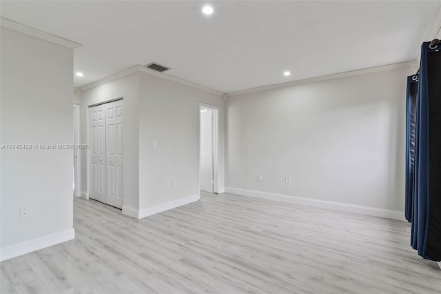 empty room with light wood-type flooring and crown molding