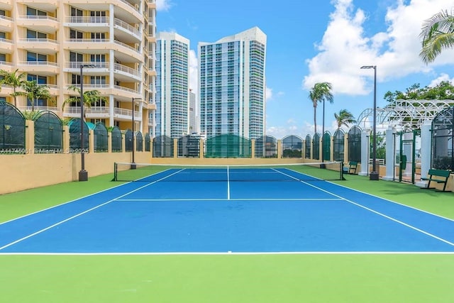 view of tennis court featuring basketball hoop