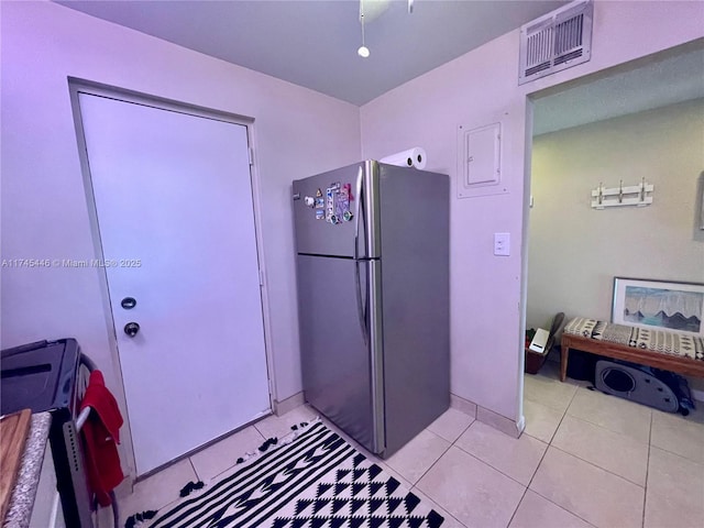 kitchen featuring light tile patterned flooring and stainless steel refrigerator