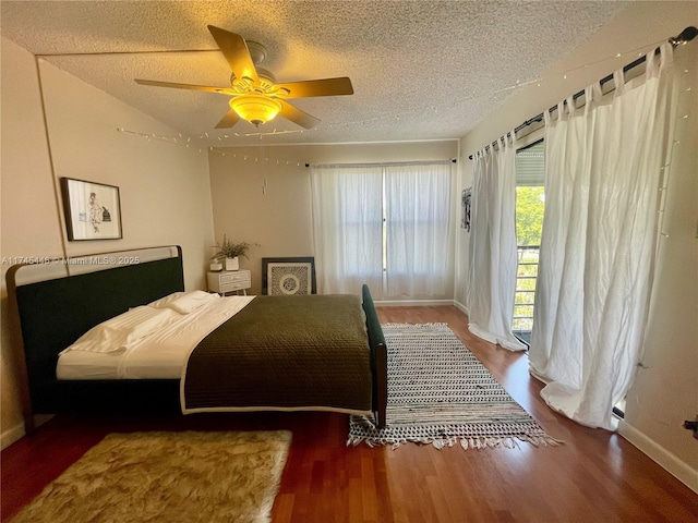 bedroom with hardwood / wood-style floors, a textured ceiling, and ceiling fan