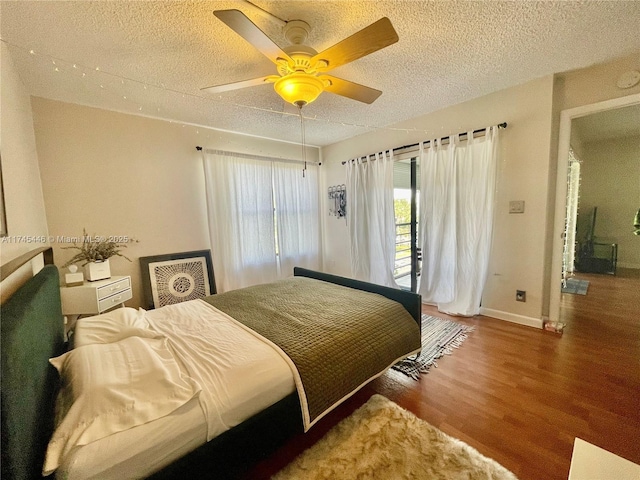 bedroom with hardwood / wood-style floors, access to exterior, a textured ceiling, and ceiling fan