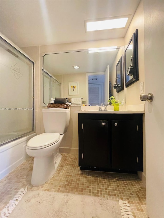 full bathroom with toilet, vanity, and shower / bath combination with glass door