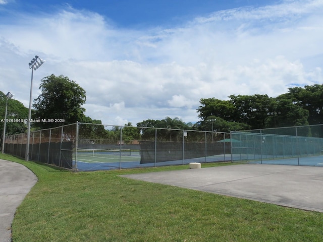 view of sport court featuring a lawn