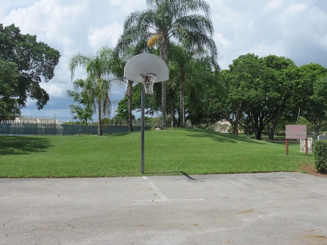 view of community featuring a yard and basketball hoop