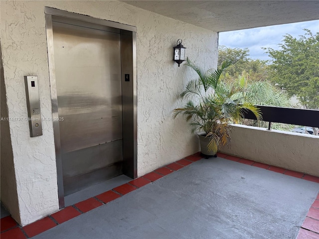 property entrance featuring a balcony and elevator