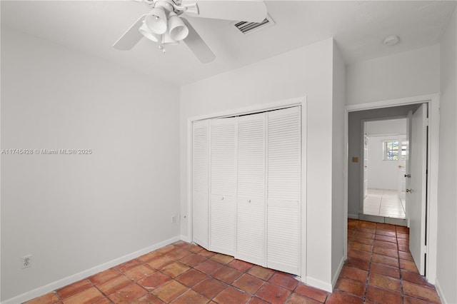 unfurnished bedroom featuring ceiling fan and a closet