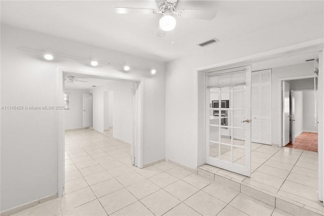 tiled empty room featuring ceiling fan