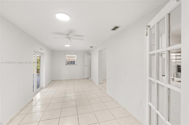 tiled spare room featuring ceiling fan