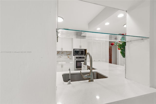 kitchen with white cabinetry, sink, decorative backsplash, and appliances with stainless steel finishes