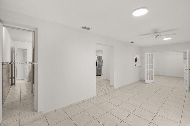 tiled empty room with french doors and ceiling fan