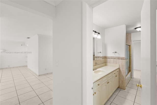 bathroom featuring tile patterned flooring, vanity, crown molding, and bath / shower combo with glass door